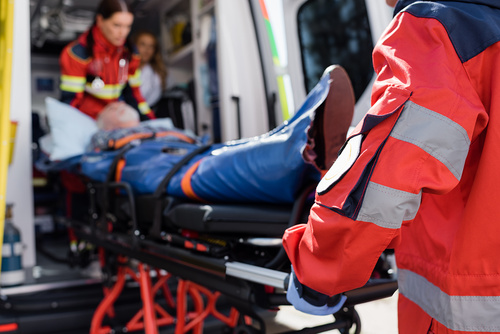 Selective focus of paramedic in uniform carrying stretcher with patient in ambulance ca outdoors / LIGHTFIELD STUDIOS - stock.adobe.com Selective focus of paramedic in uniform carrying stretcher with patient in ambulance ca outdoors