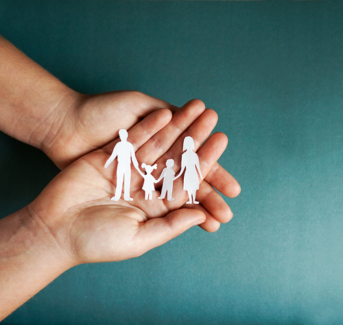 hands holding paper family cutout, social distancing concept, covid19 on the blue color background, family protection / shustrilka - stock.adobe.com hands holding paper family cutout, social distancing concept, covid19 on the blue color background, family protection